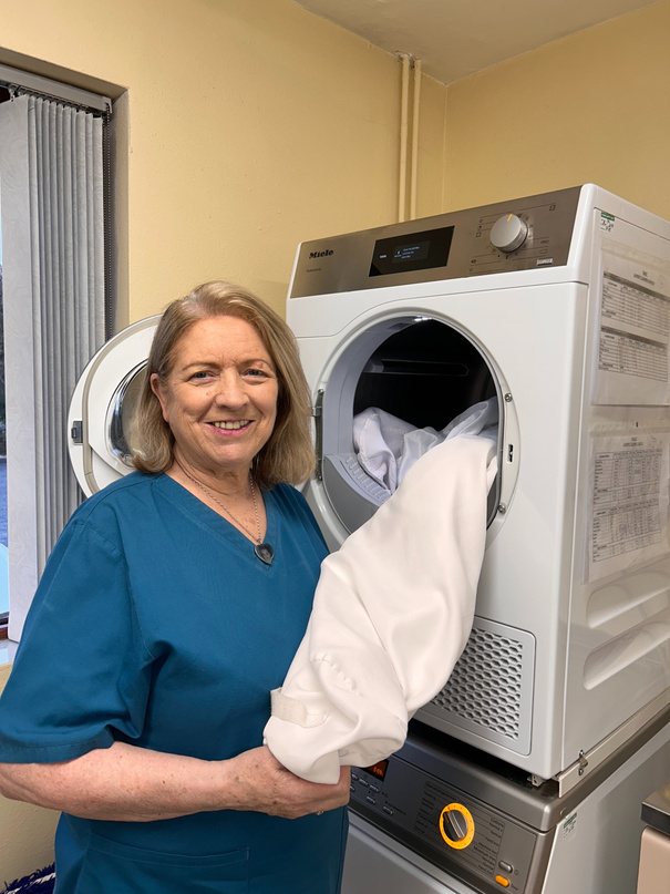 A housekeeping team member with fresh linen